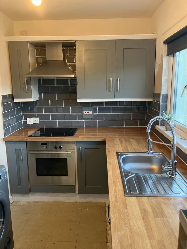 New kitchen with grey doors and wooden worktops